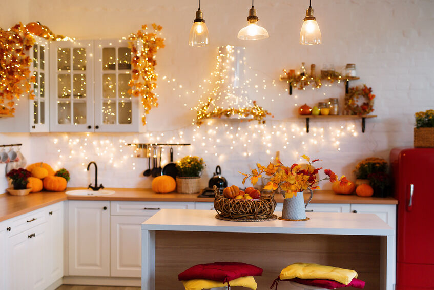Kitchen decorated with lights, garland and pumpkins for the holidays